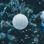 Large decorative balls hanging from an evergreen tree
